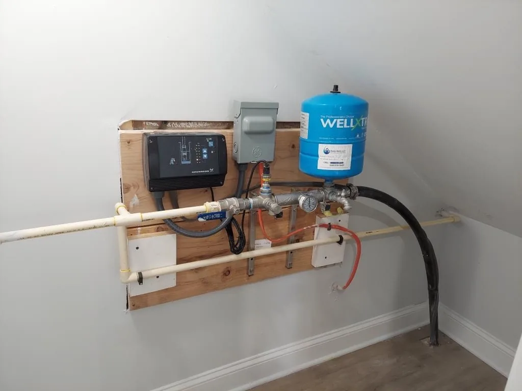 Constant pressure system on a basement wall: the controller, a small pressure tank, a pressure gauge and the well line
