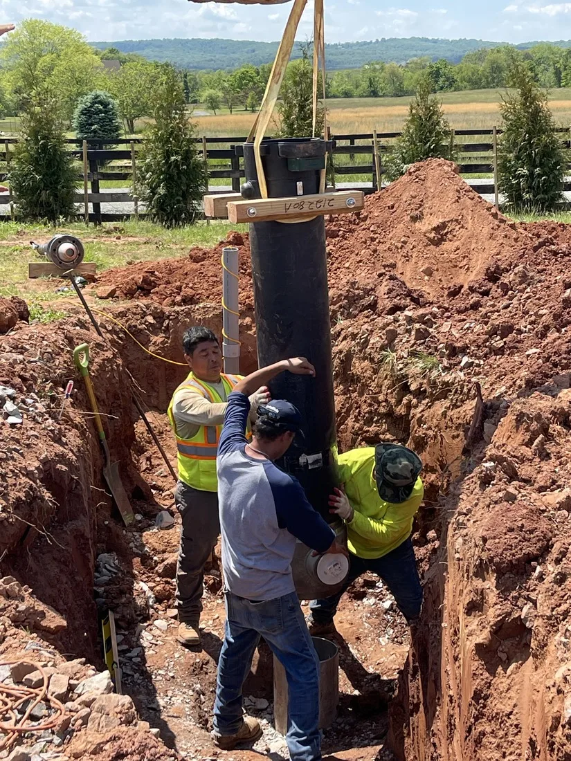 Crew setting steel well casing on a drilling job