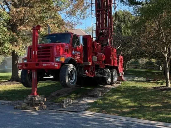 HydroWells drill rig levelled on outrigger pads and ground mats on a lawn