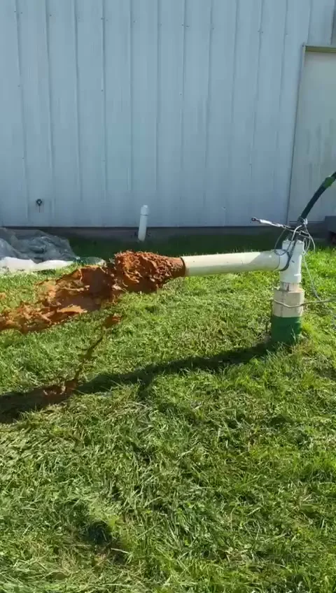 Rust-colored iron water flushed out of a well during cleaning on a Maryland lawn